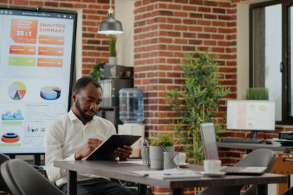 African american man greeting team of coworkers in startup office