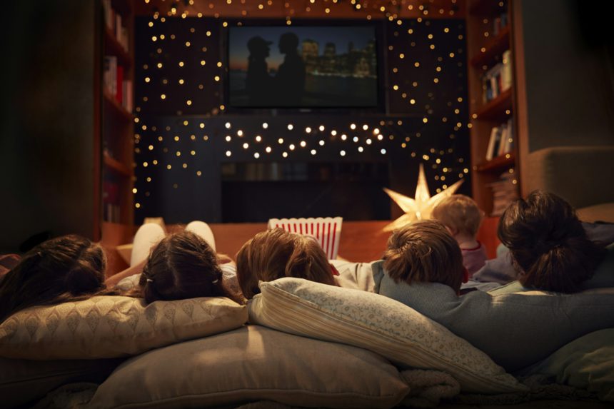 Family Enjoying Movie Night At Home Together