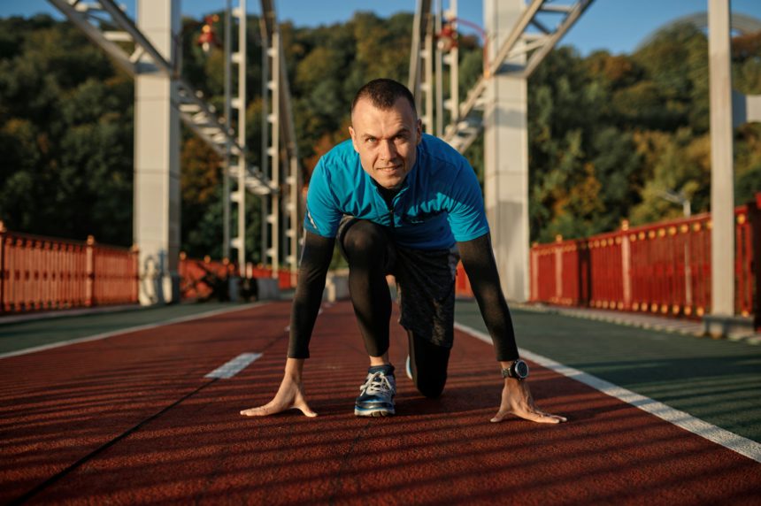 Fitness runner doing warm-up routine before speed running