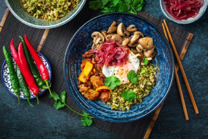 Ketogenic diet bowl with organic cauliflower and broccoli rice, stir fried chicken, mushrooms, egg