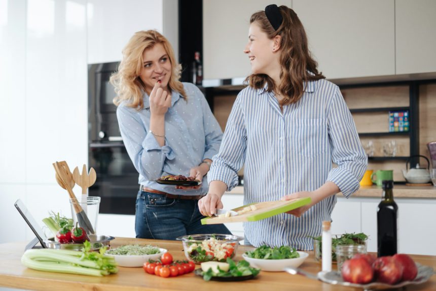 Mother and daughter teenager cooking together