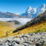 Two people riding bicycles in the mountains. A team sport. Cyclists in a mountain valley in the Alps