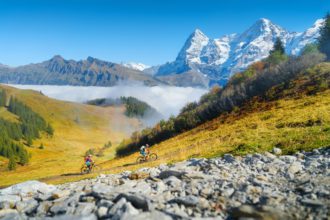 Two people riding bicycles in the mountains. A team sport. Cyclists in a mountain valley in the Alps