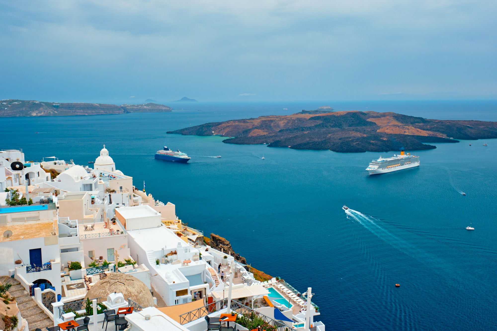 View of Fira town on Santorini island with cruise ships in sea
